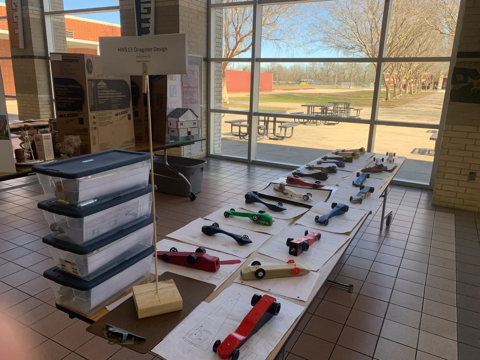 CO2 dragsters lined up with their design sheets for judging