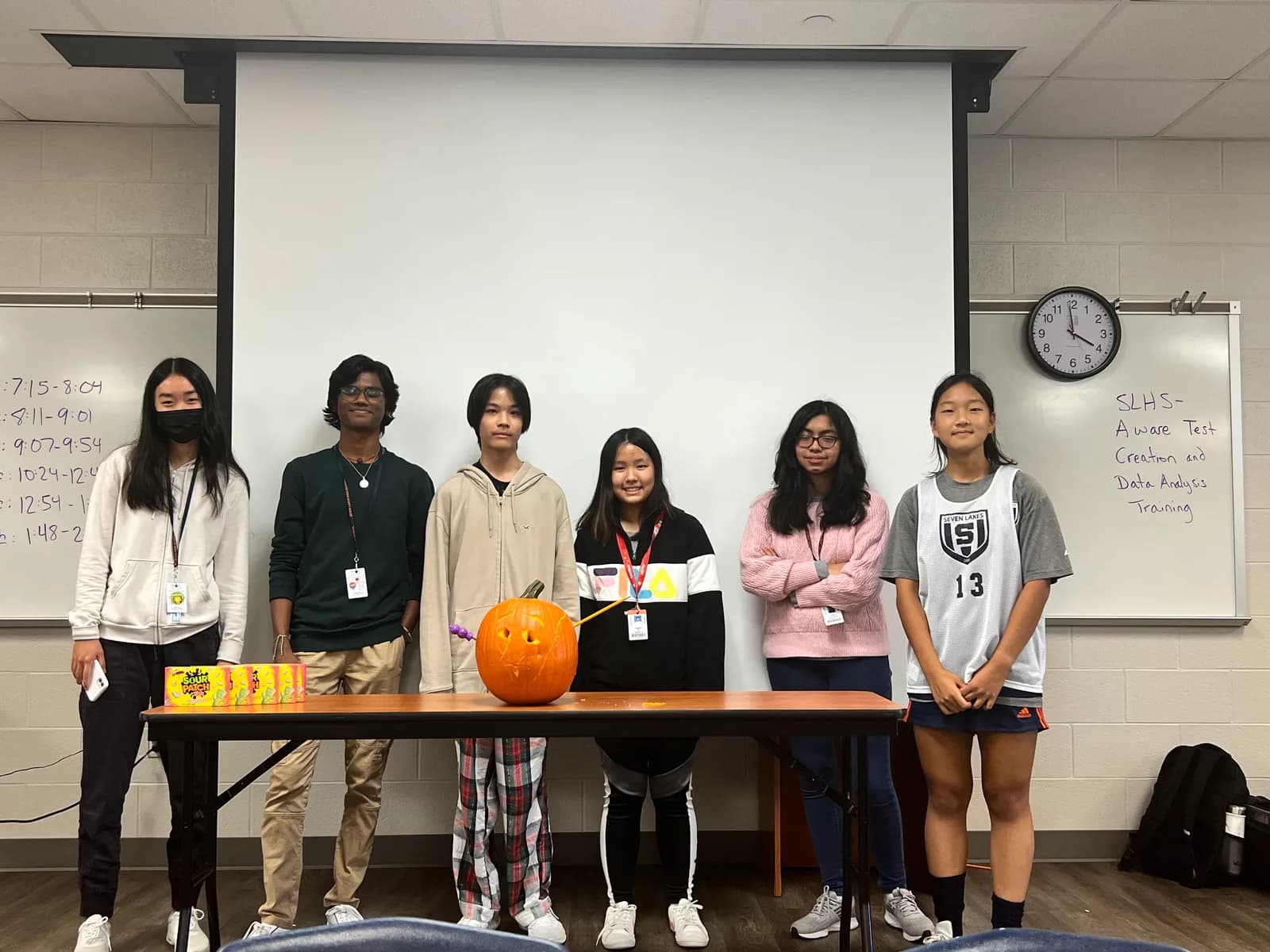 Members with their glowing jack-o-lantern on the table