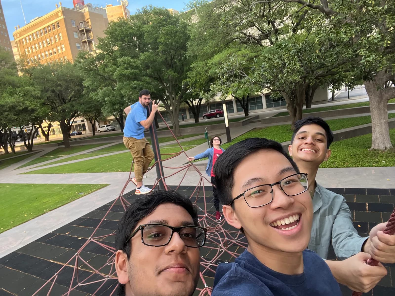 Members take a selfie on a climbing sculpture in a downtown park