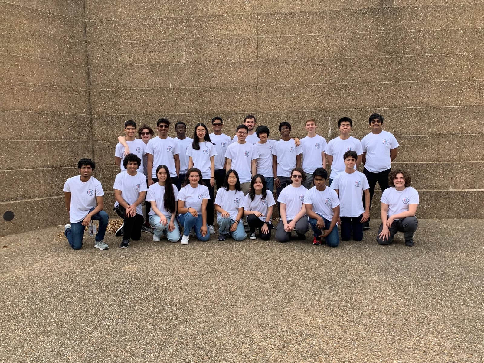 Full chapter photo in matching shirts in front of the stone wall
