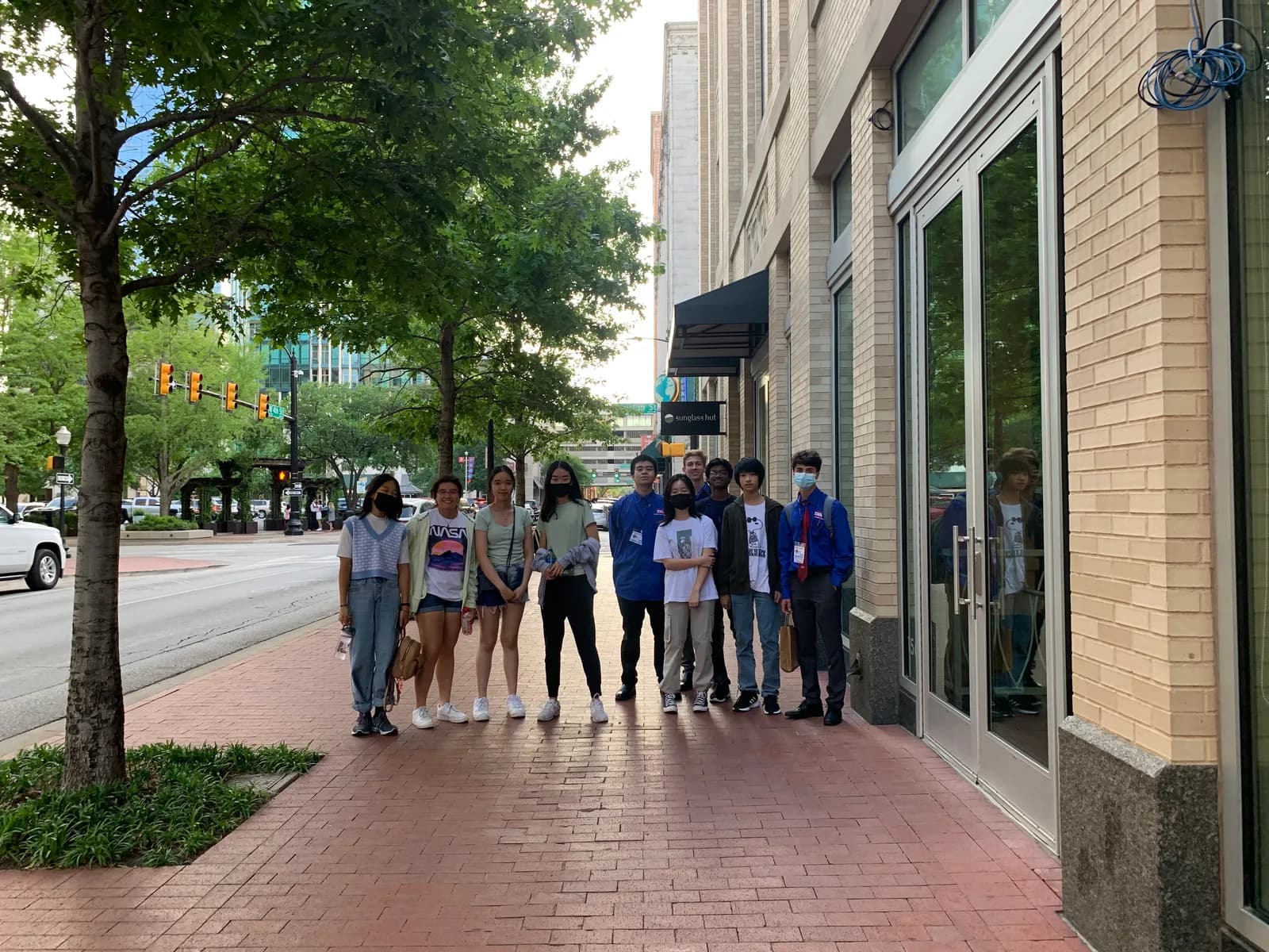 Members gathered on the red brick sidewalk downtown