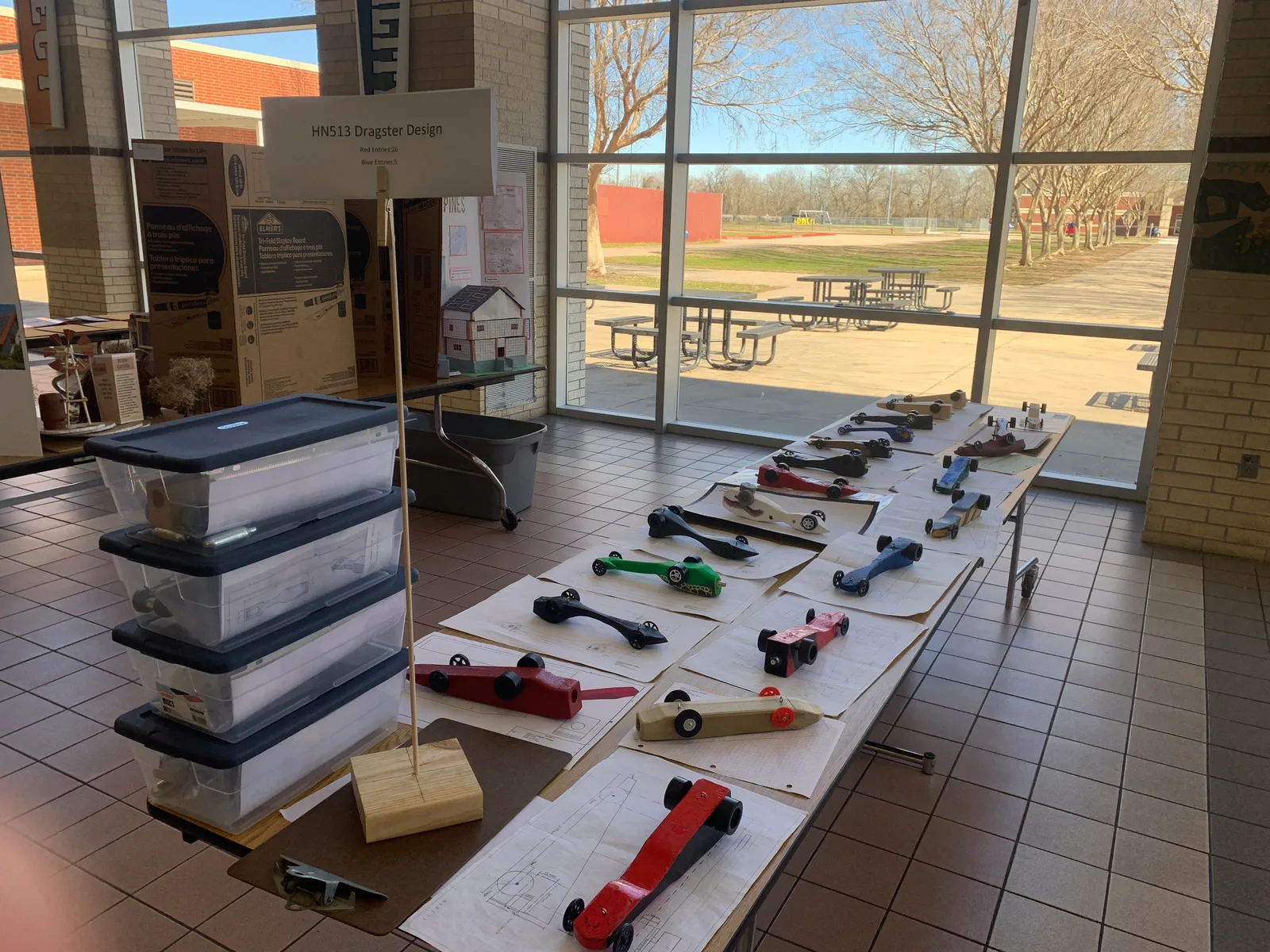 CO2 dragsters lined up with their design sheets for judging