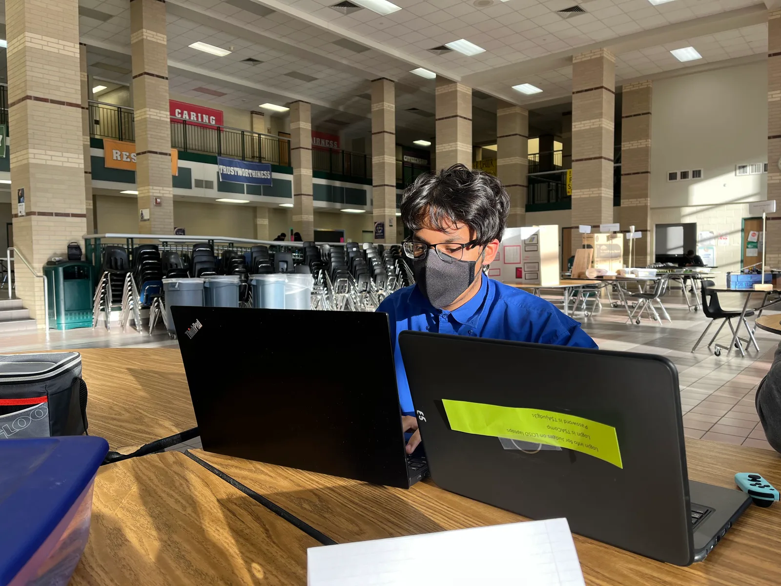 Member focused between two laptops during the competition