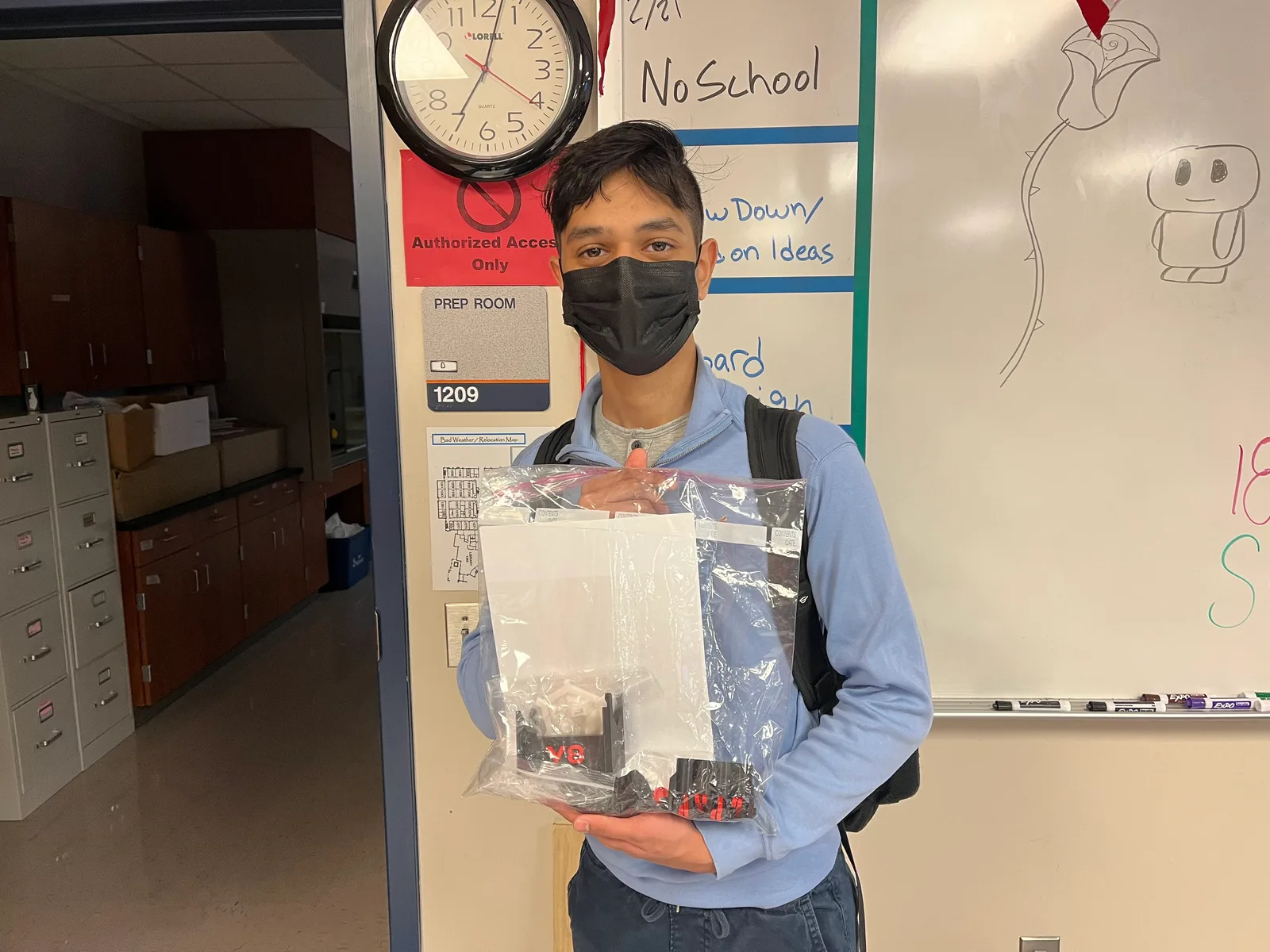 Member holding a sealed competition kit bag in the classroom