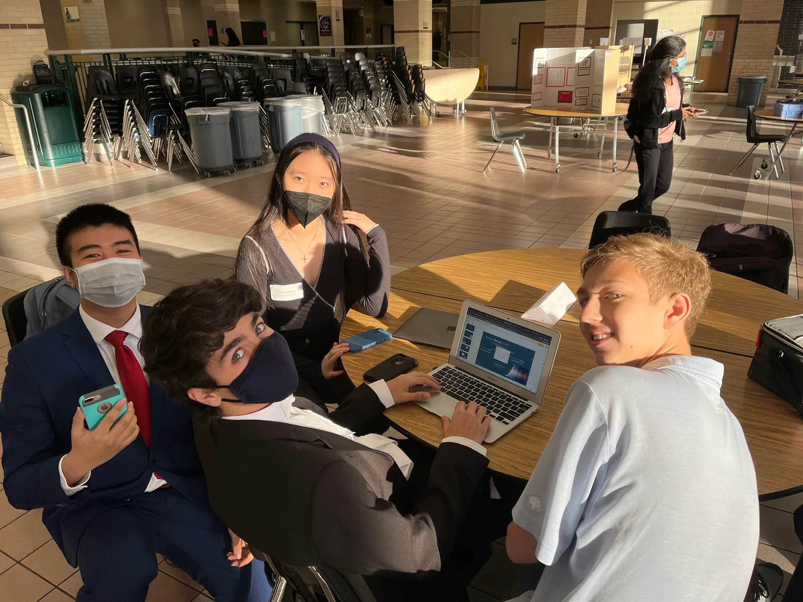 Team working at a laptop as afternoon sun fills the cafeteria