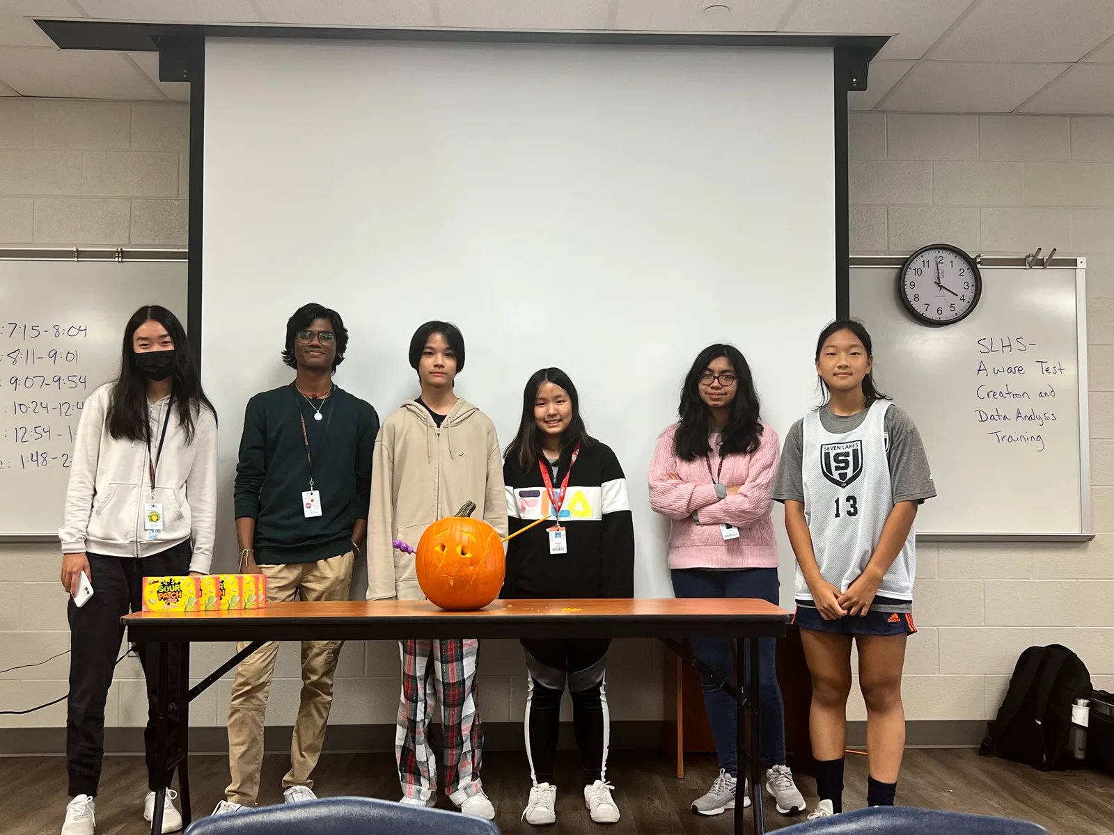 Members lined up behind their pumpkin and candy prizes