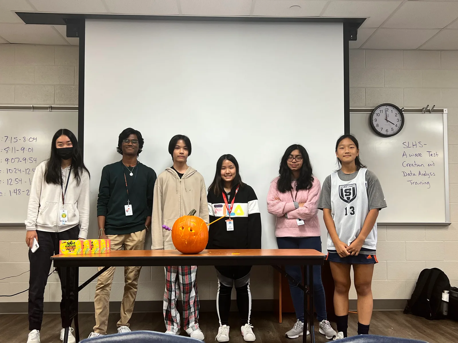 Members with their glowing jack-o-lantern on the table