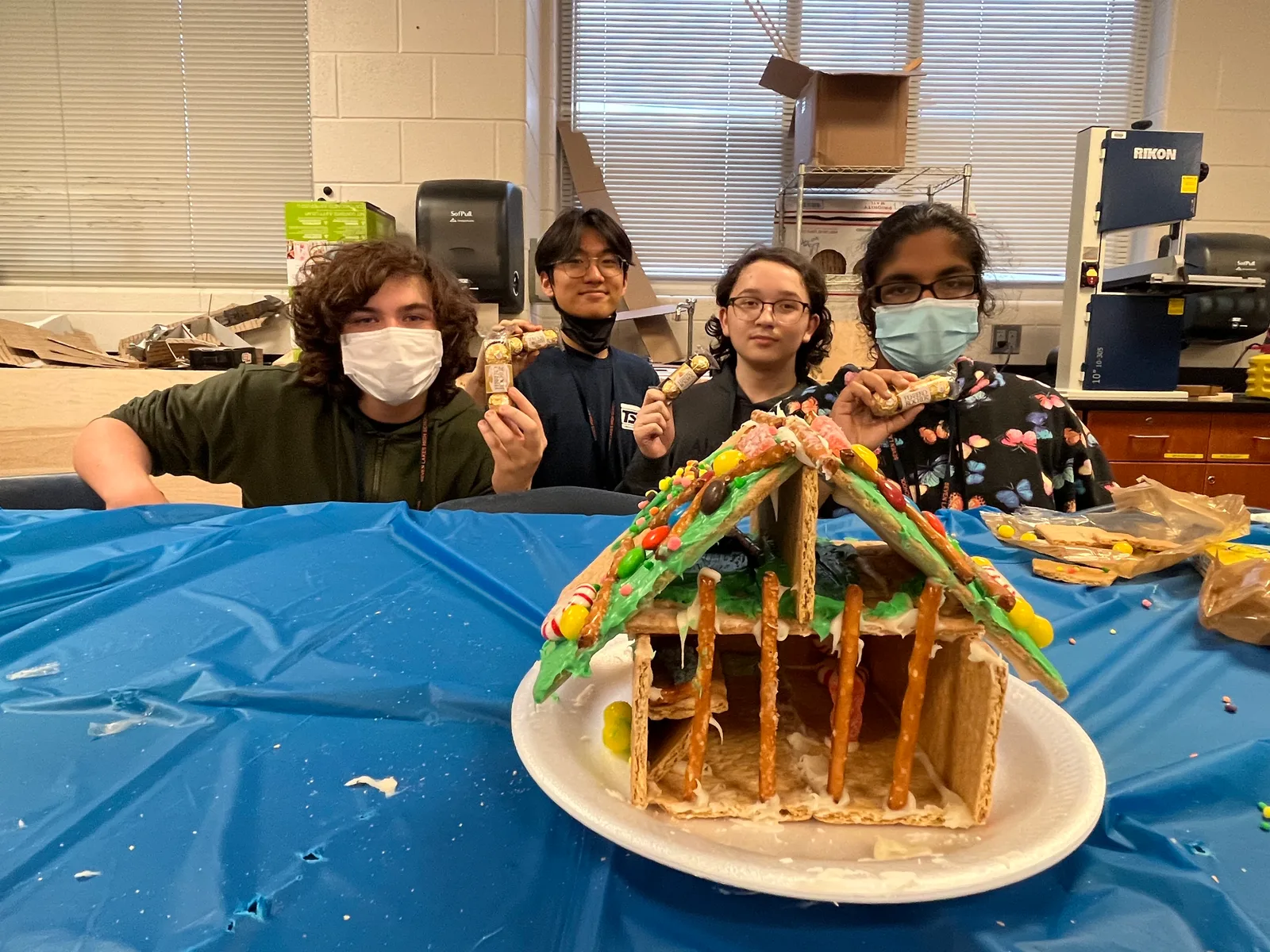 Members presenting their candy-covered gingerbread house