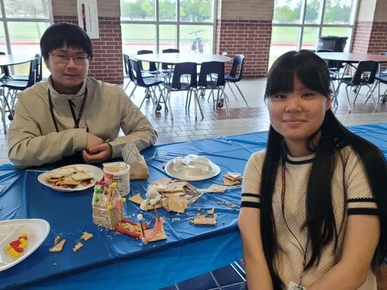 Members at the blue table with their builds and snacks