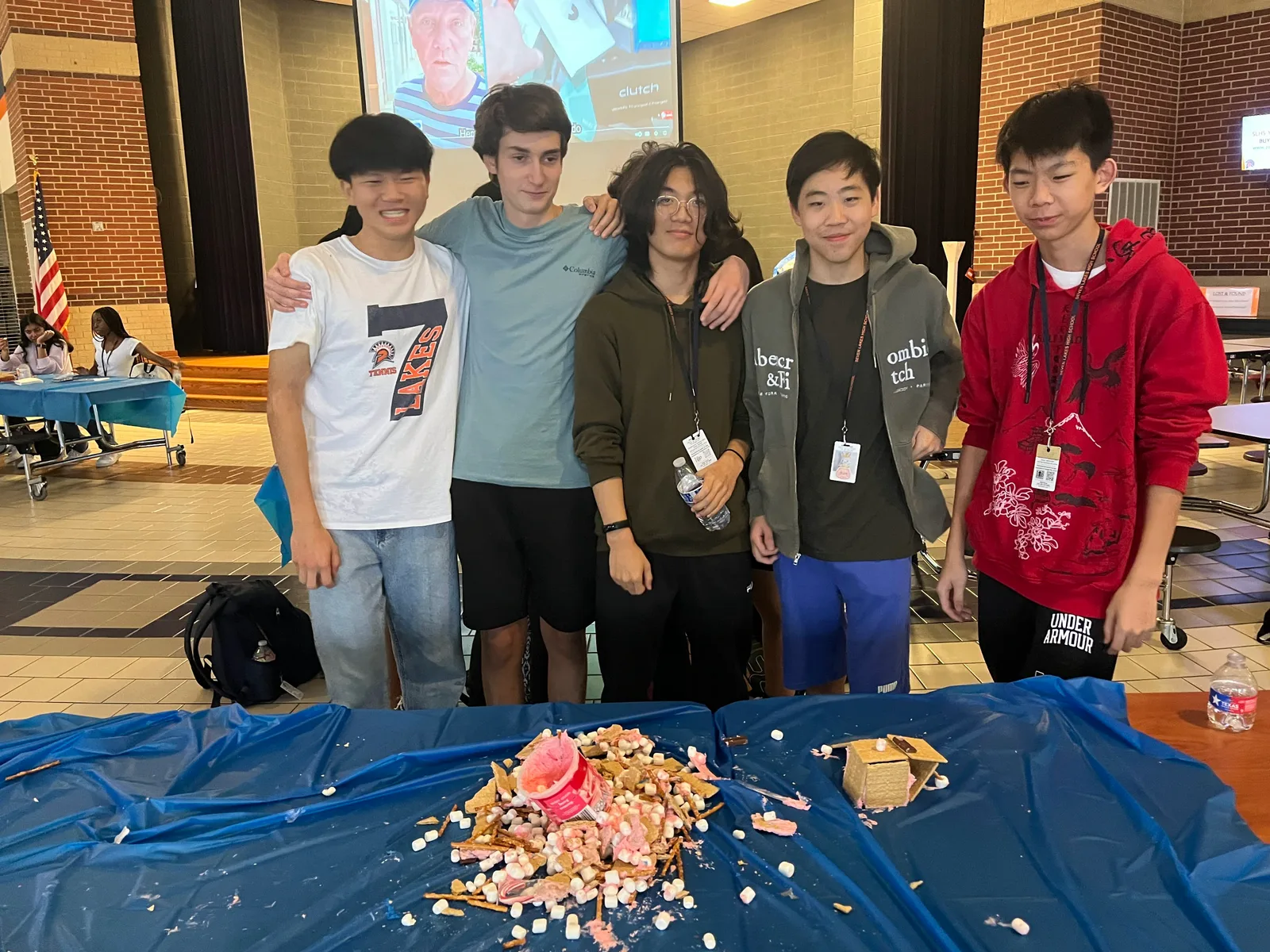 Members posing behind the aftermath of their candy build