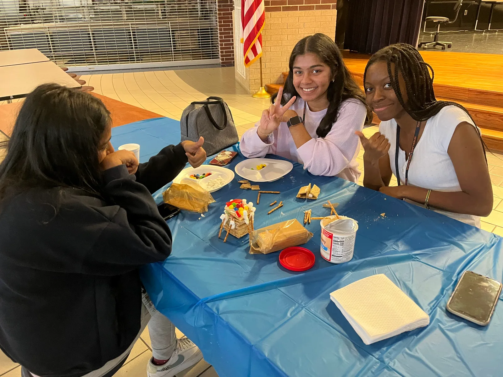 Members flashing peace signs over the build table