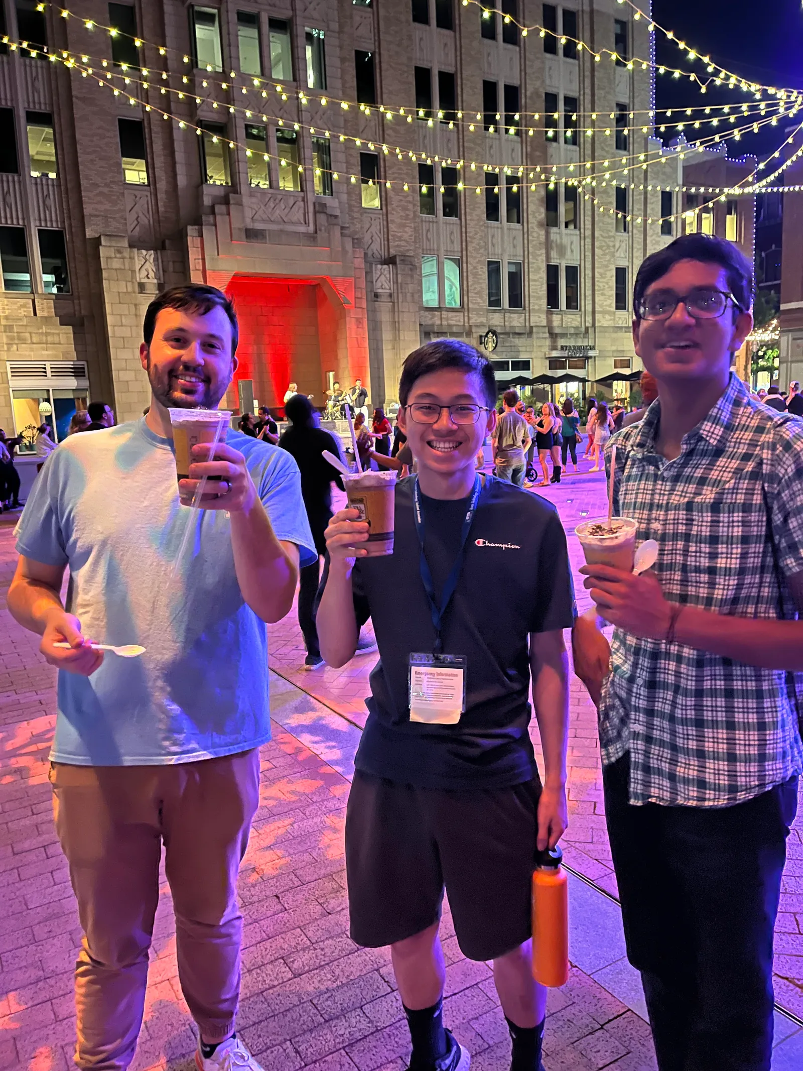 Members enjoying iced drinks downtown under string lights at State