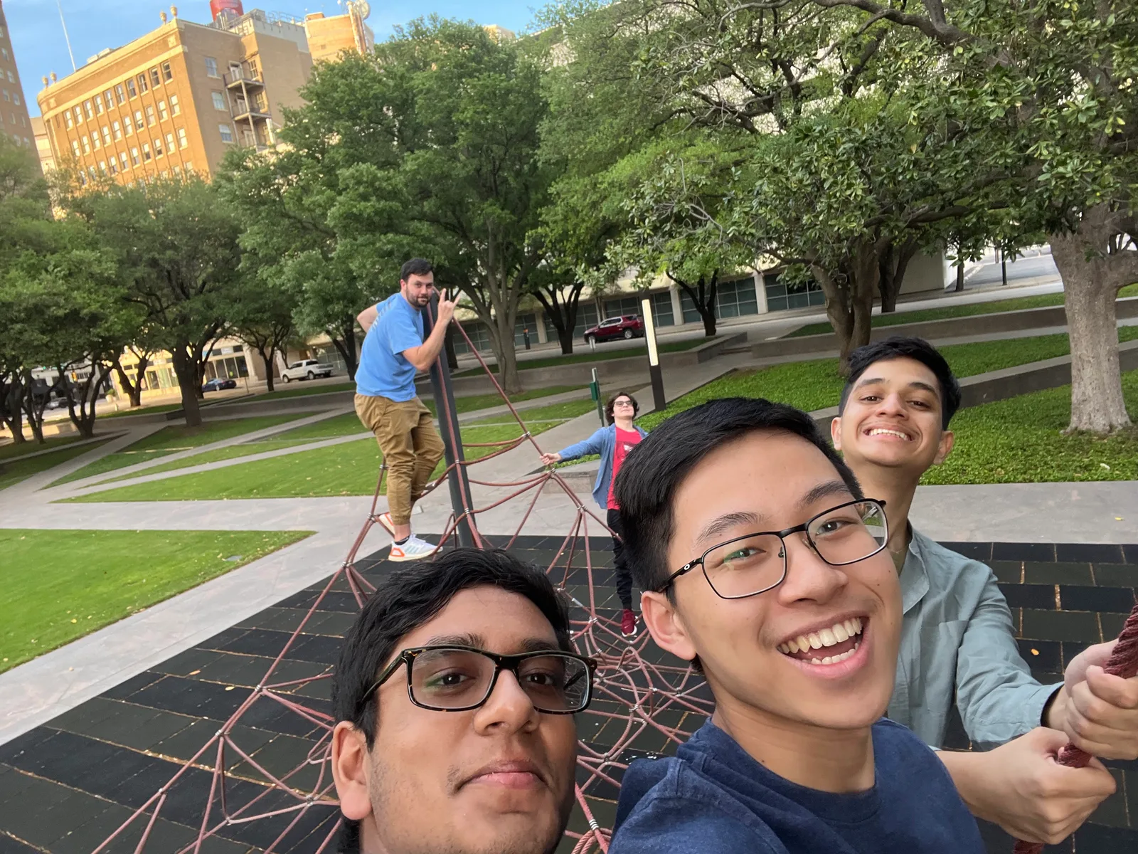 Members take a selfie on a climbing sculpture in a downtown park