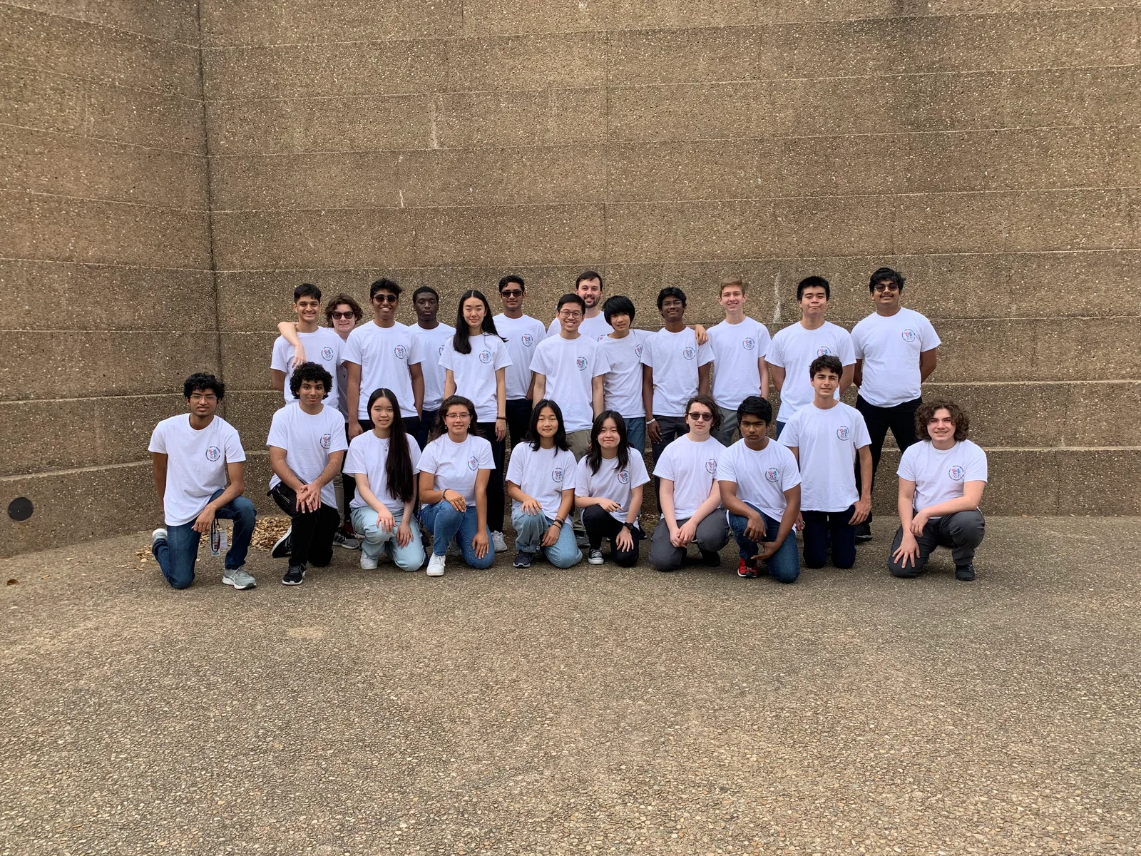 Full chapter photo in matching shirts in front of the stone wall