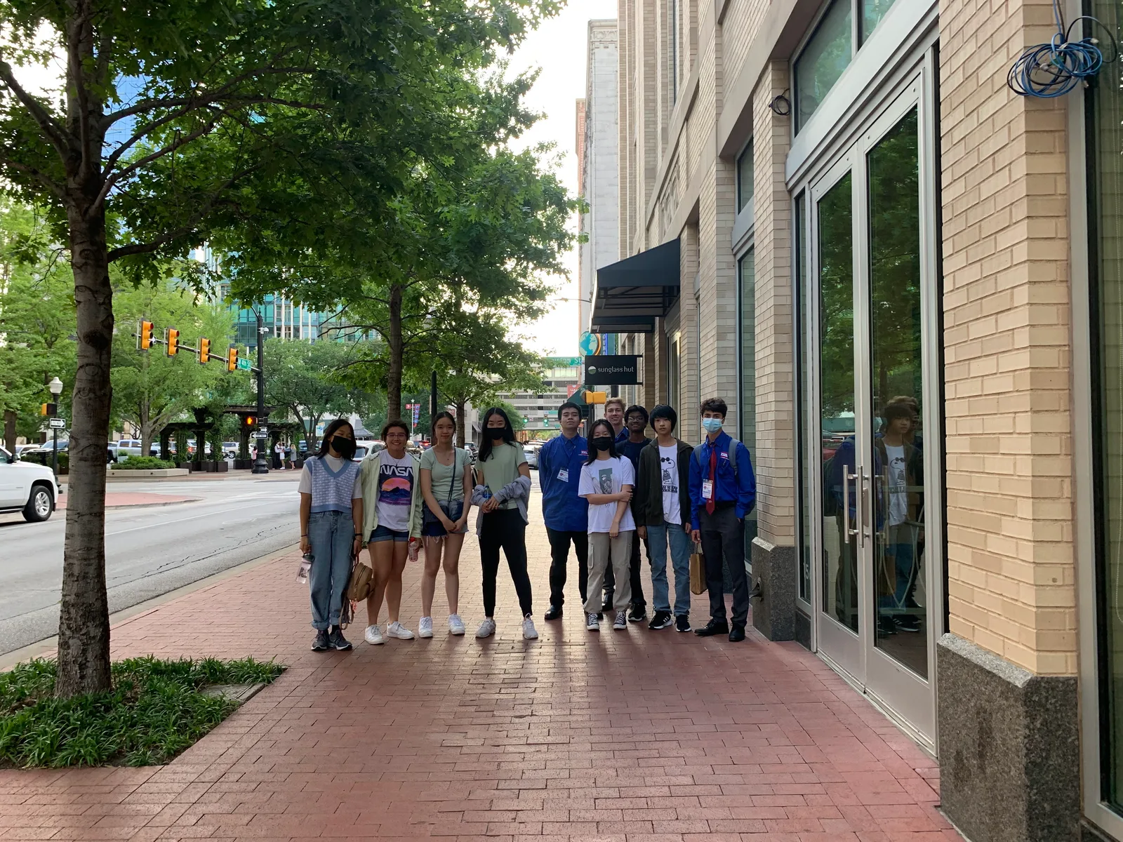 Members gathered on the red brick sidewalk downtown