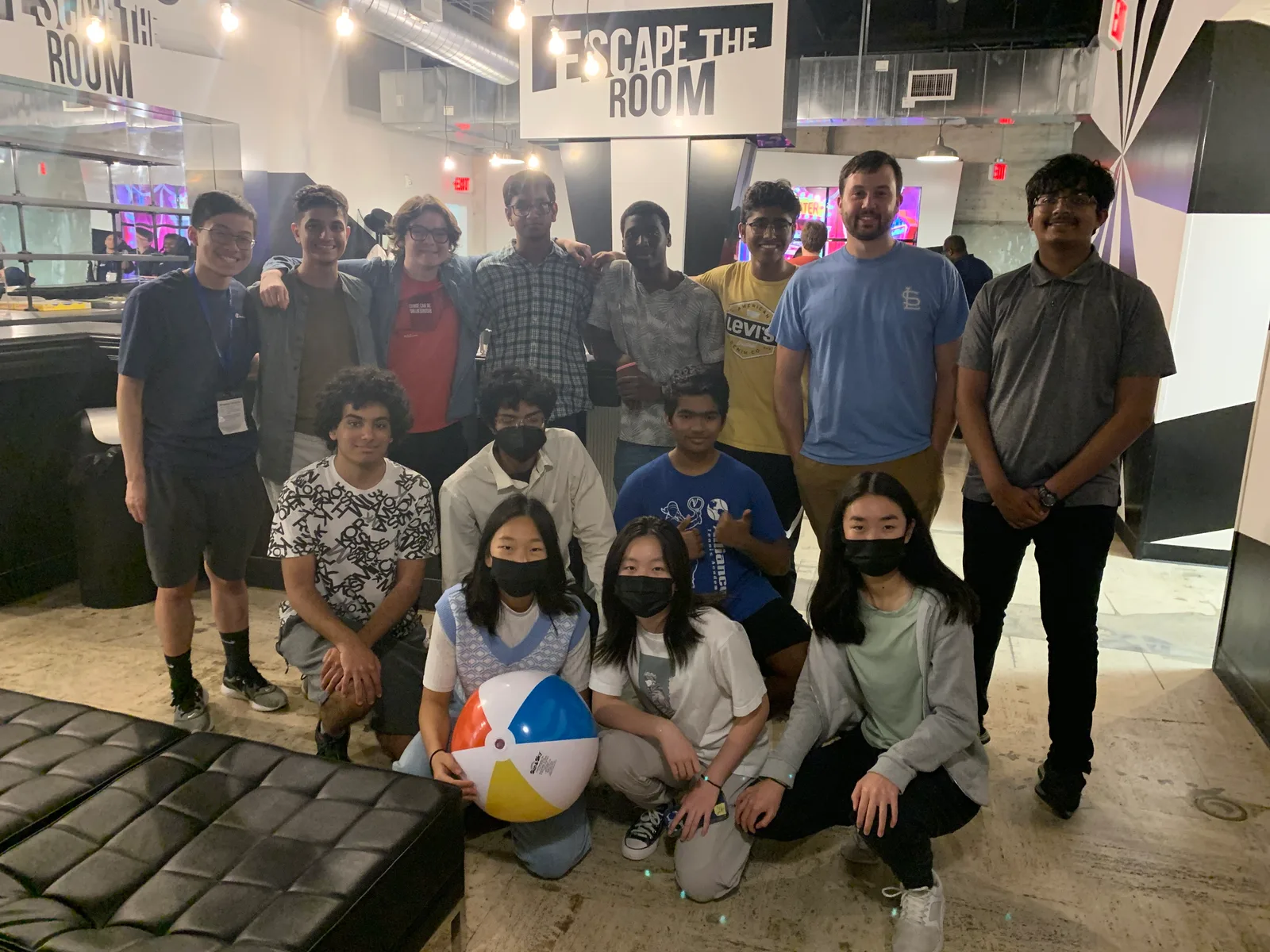 Group photo with a beach ball at the Escape The Room lobby