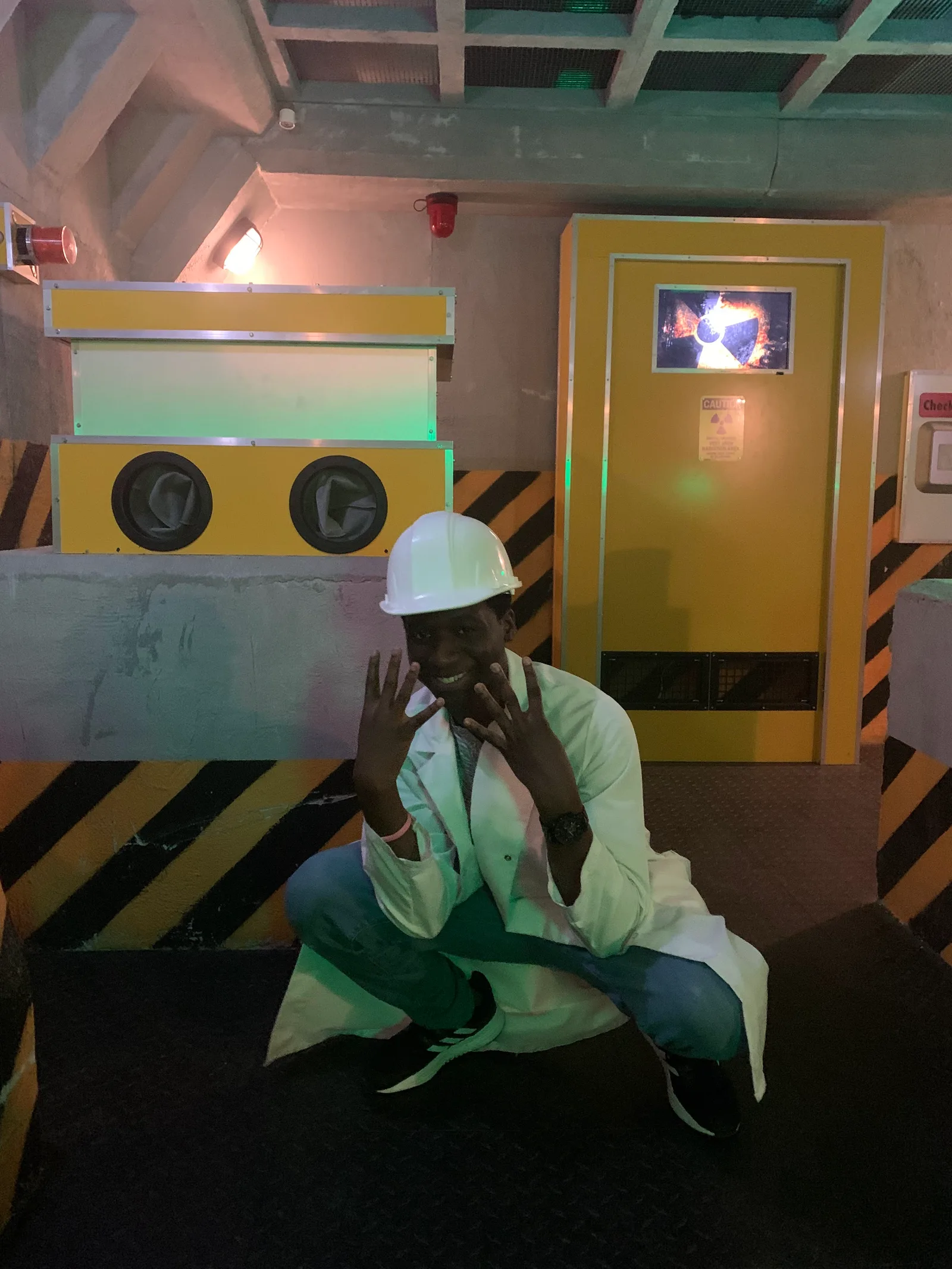 Member in lab coat and hard hat inside the escape room set