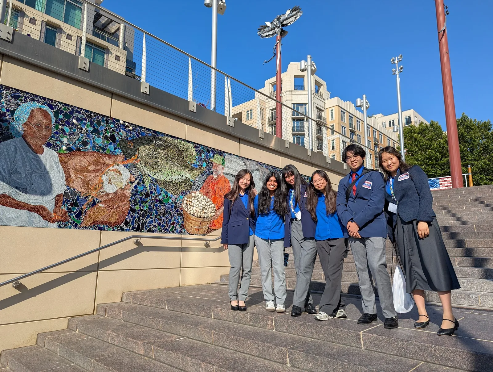 Members in official dress pose on the mosaic steps at National Harbor in the evening sun