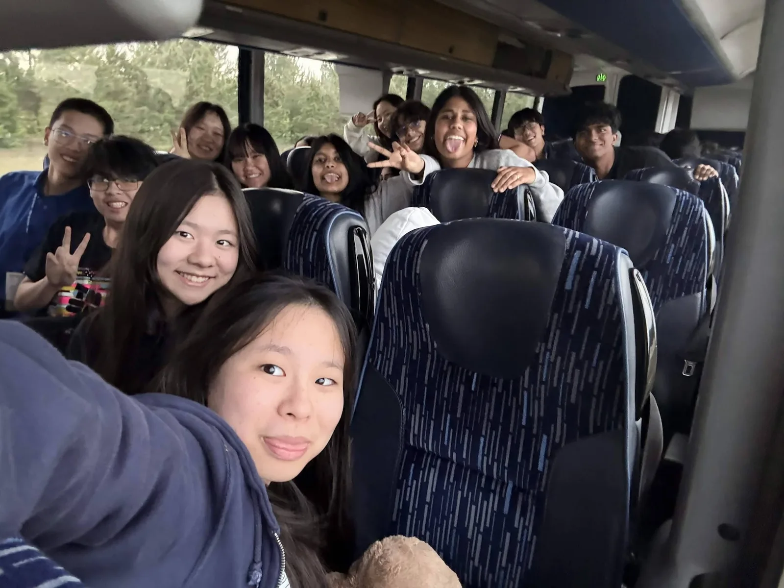 SLHS TSA members packed across charter bus seats flashing peace signs on the ride to the 2026 Texas TSA State Conference