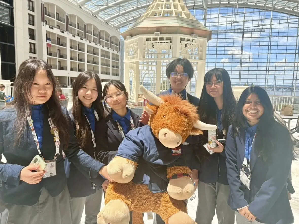 SLHS TSA members posing with Lex the longhorn plush at the Gaylord National atrium